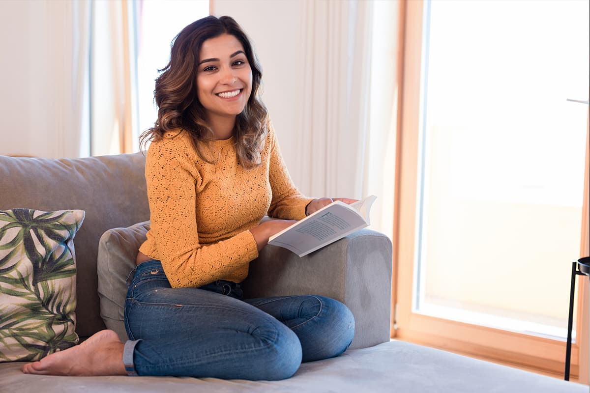 Vrouw leest boek op de bank