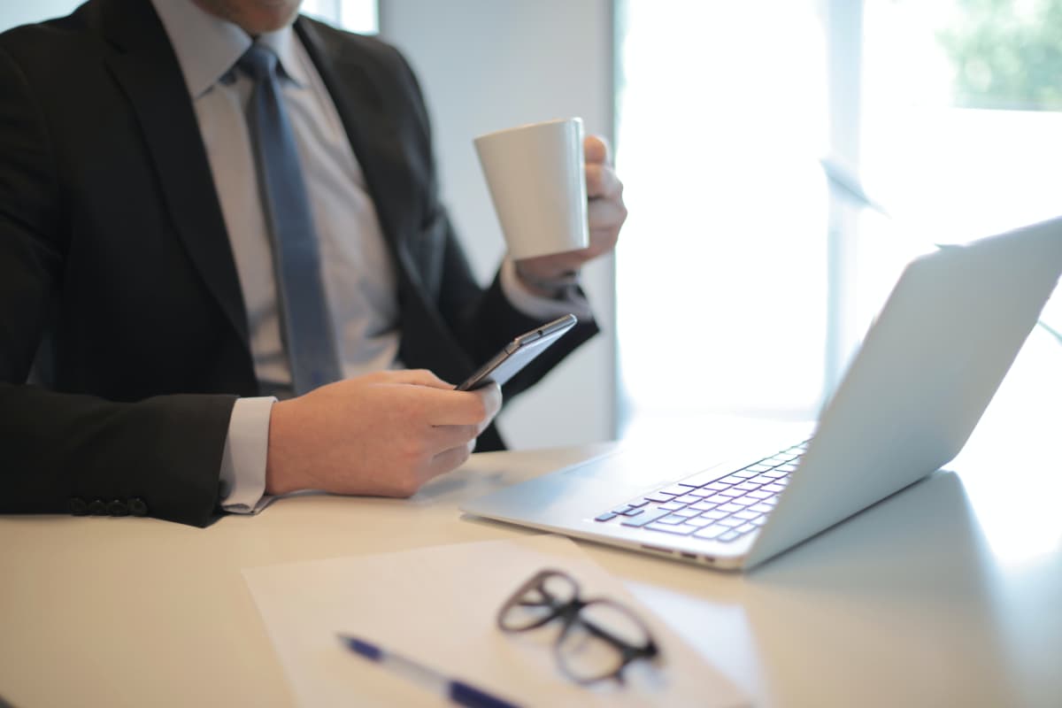 Man in Black Suit Drinking Coffee
