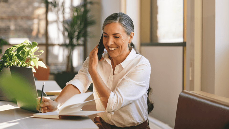Women speaking on the telephone while working on laptop